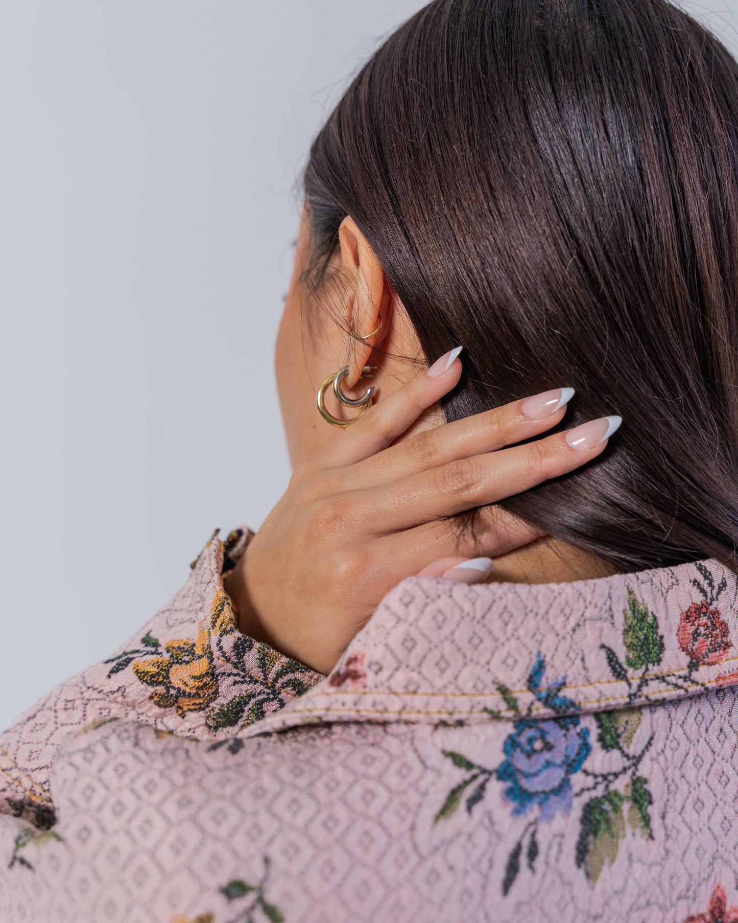 Close up on a person wearing a floral-patterned jacket showing top stitching and texture details