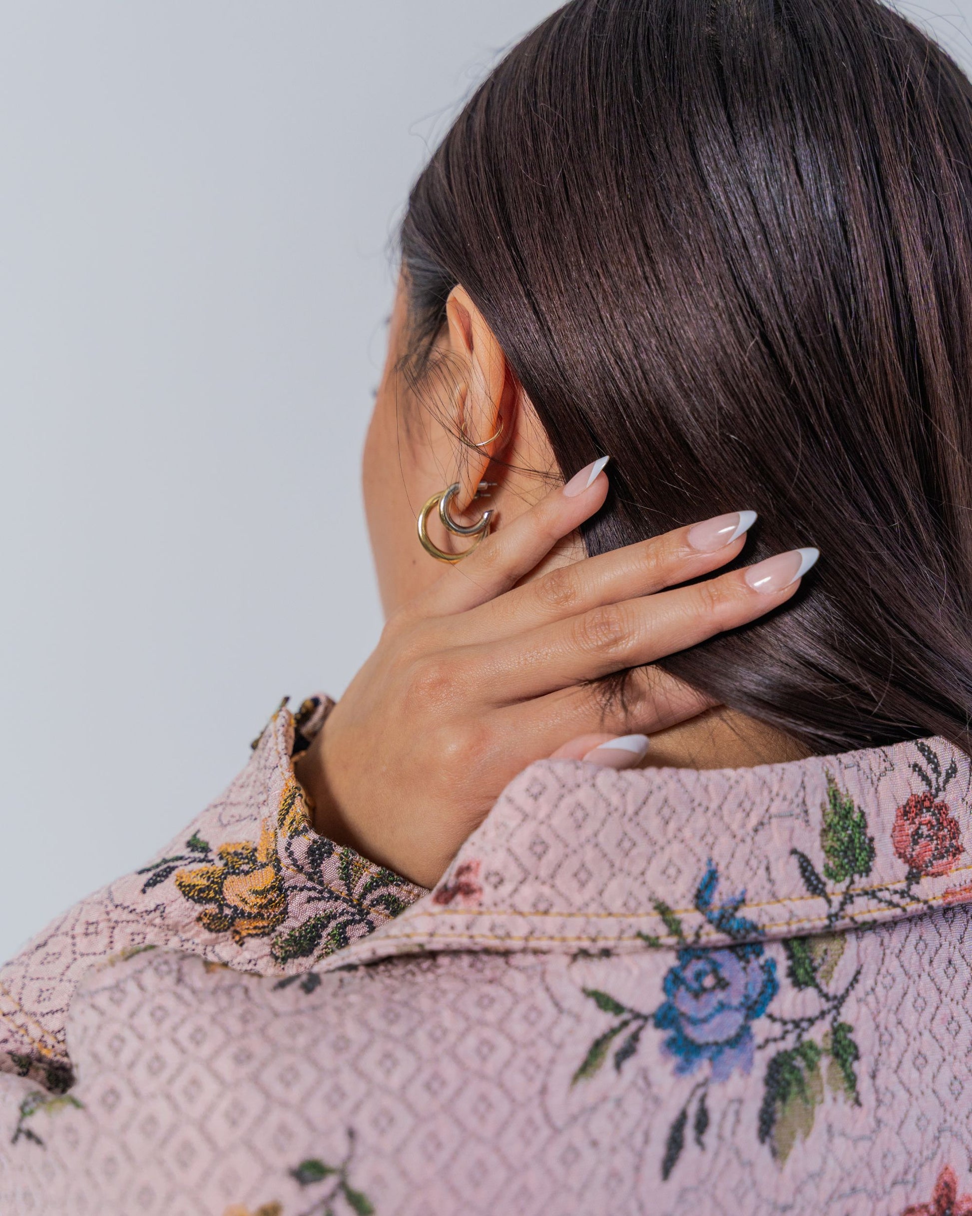 Close up on a person wearing a floral-patterned jacket showing top stitching and texture details