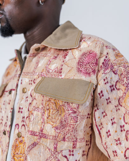 Close-up on the pocket of a person wearing a patterned jacket made from sustainable upcycled fabric with a neutral background