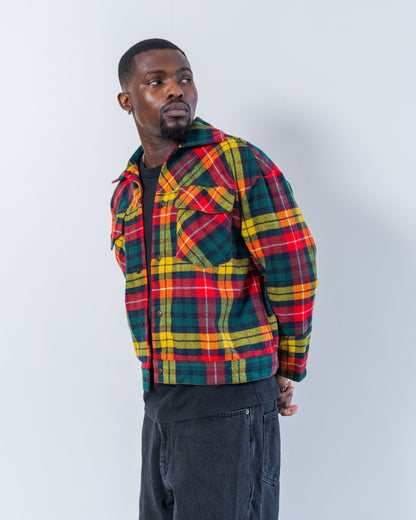 Person wearing a colorful upcycled wool plaid jacket against a white background
