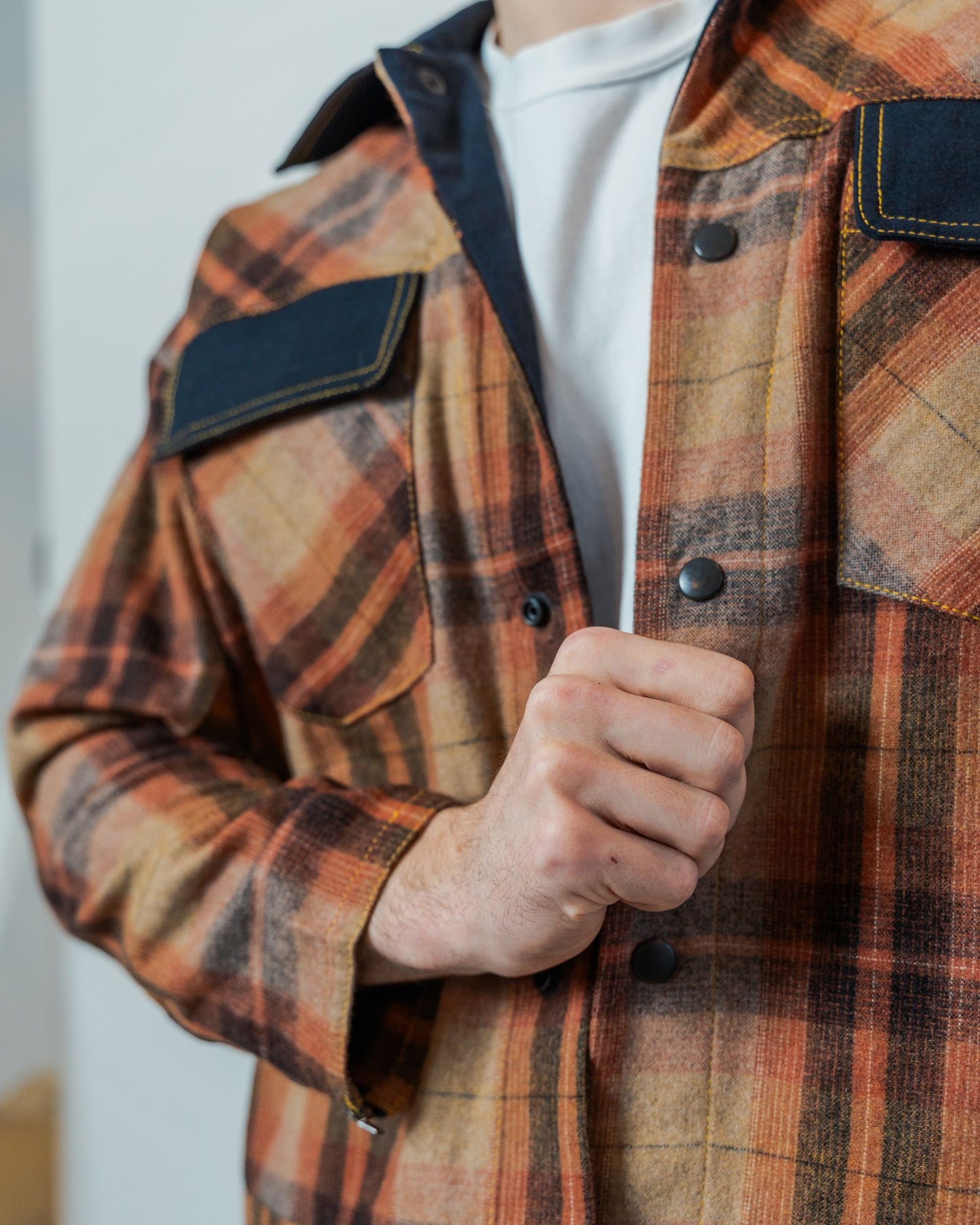 Brown plaid jacket with black detailing and snaps made from sustainable upcycled fabric.