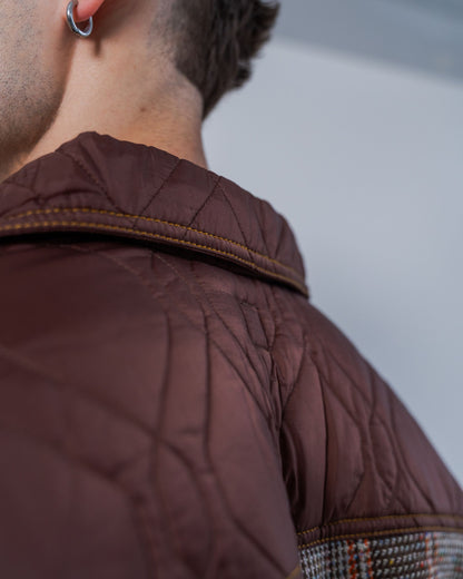 Close-up of on the brown quilted back panel of the jacket with a neutral background