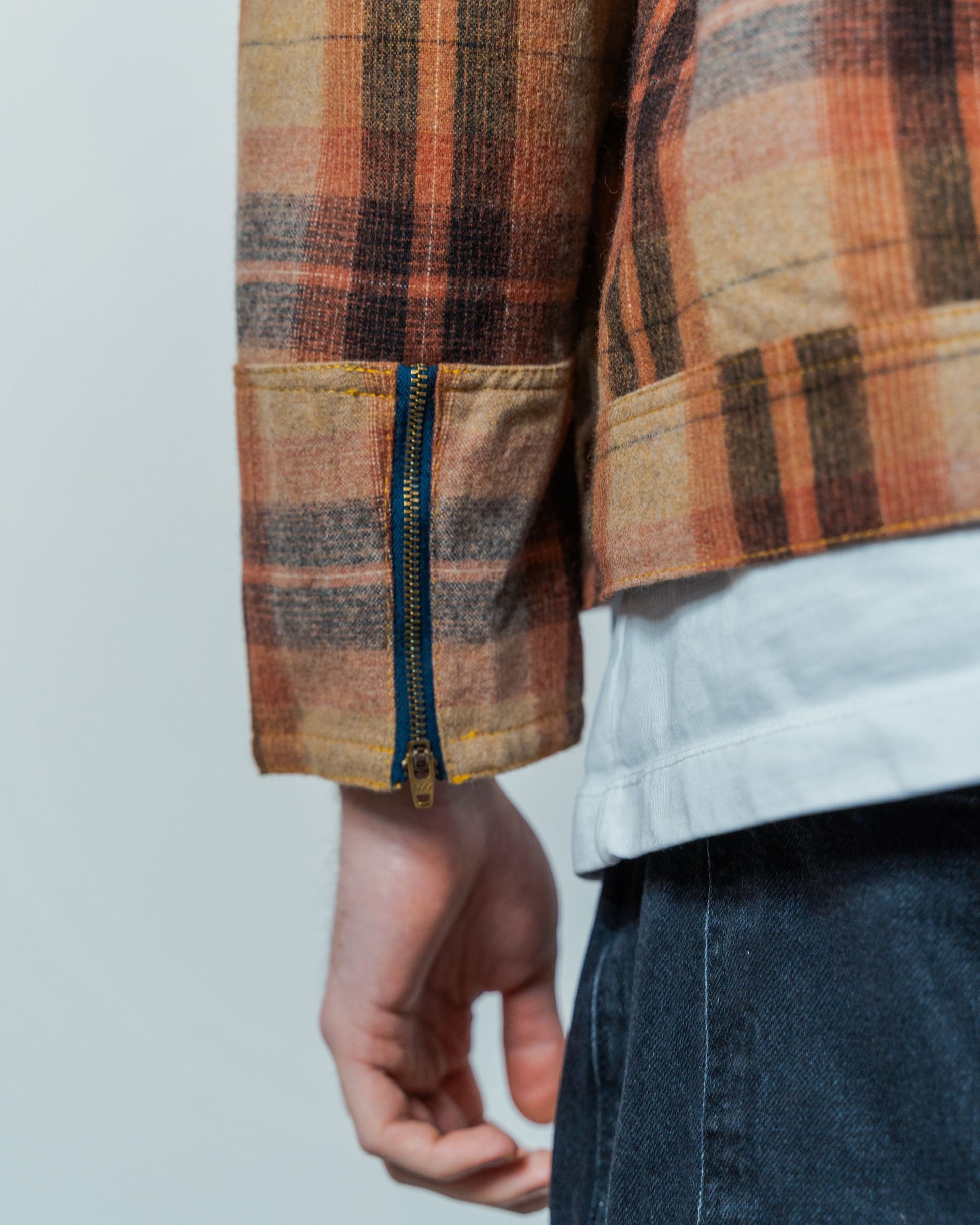 Close-up of a plaid jacket with a zipper on a plain background