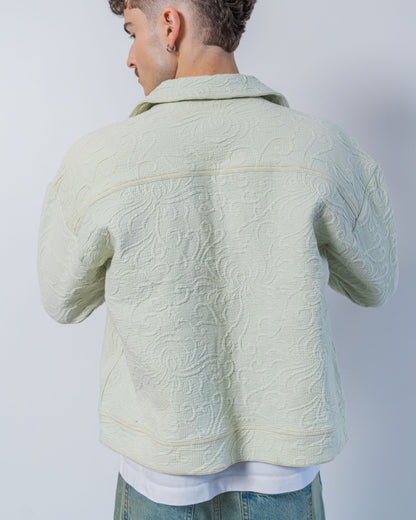 Light green sage textured jacket worn by a person on a plain background. The jacket is made sustainably from upcycled materials.