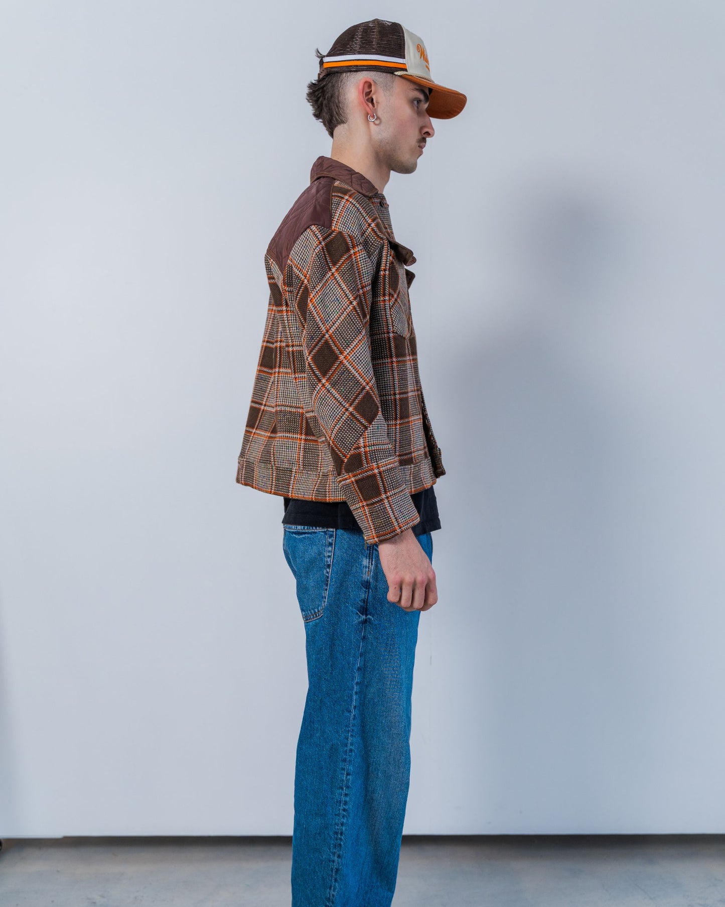Person wearing a brown wool plaid jacket made with sustainable upcycled materials.