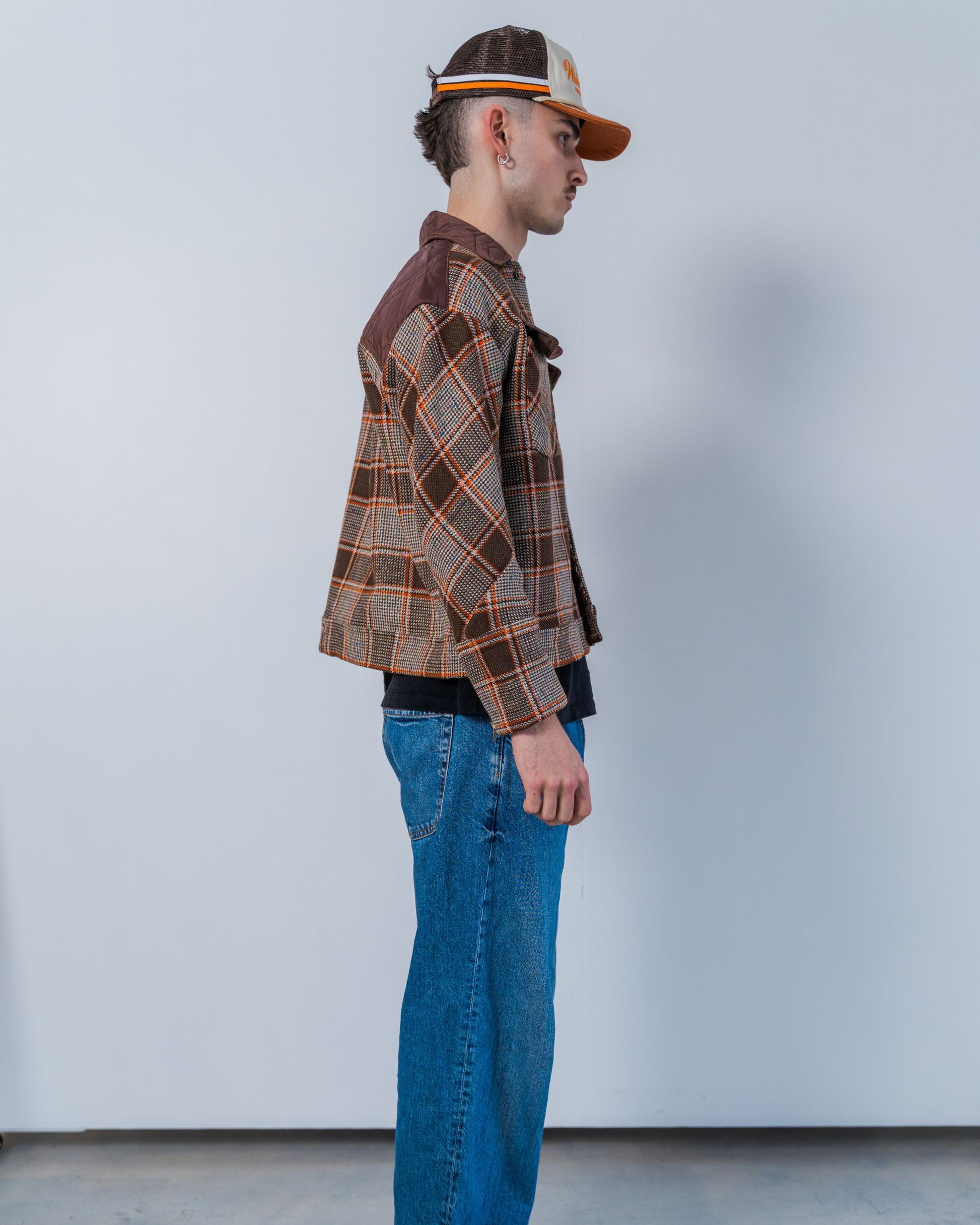 Person wearing a brown wool plaid jacket made with sustainable upcycled materials.