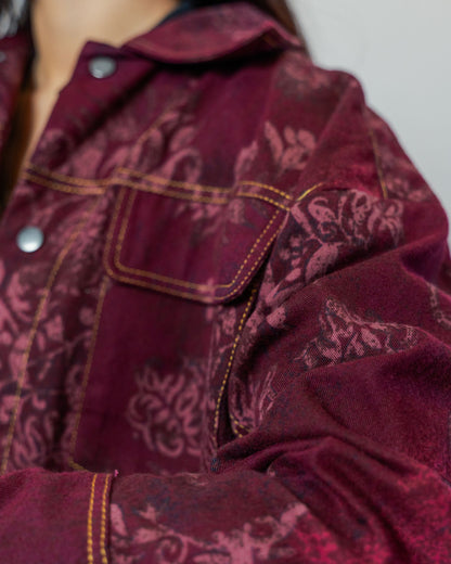 Close-up of a burgundy red patterned jacket gold top stitching made from sustainable upcycled materials.