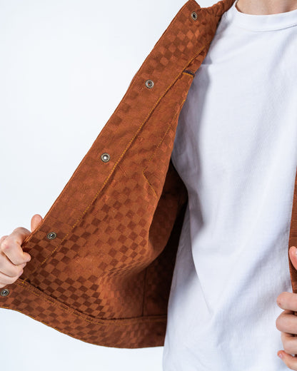 Brown checkers patterned jacket with snaps held by a person wearing a white shirt on a white background