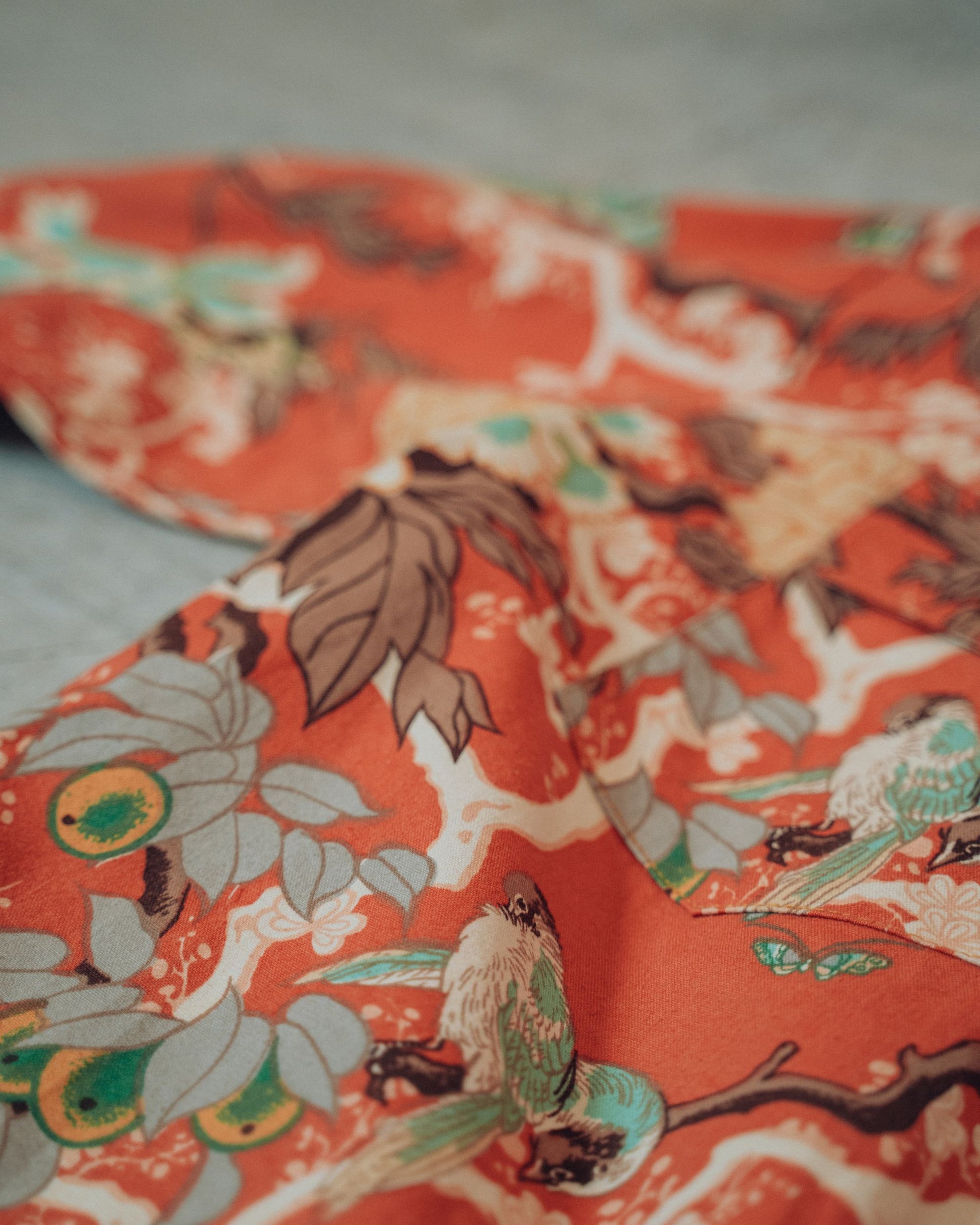 Close-up of floral fabric with birds on a concrete floor