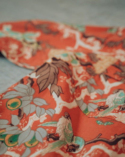 Close-up of floral fabric with birds on a concrete floor
