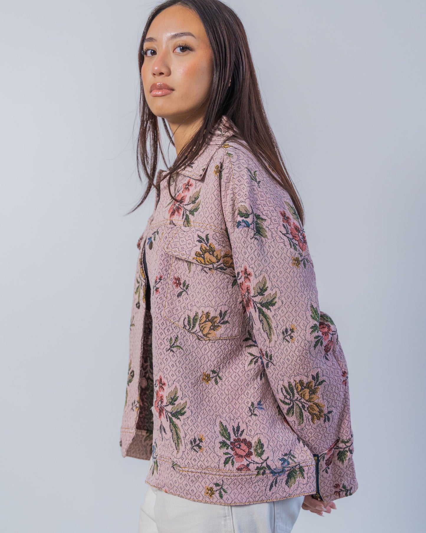 Woman wearing a floral patterned jacket made from sustainable upcycled fabric.