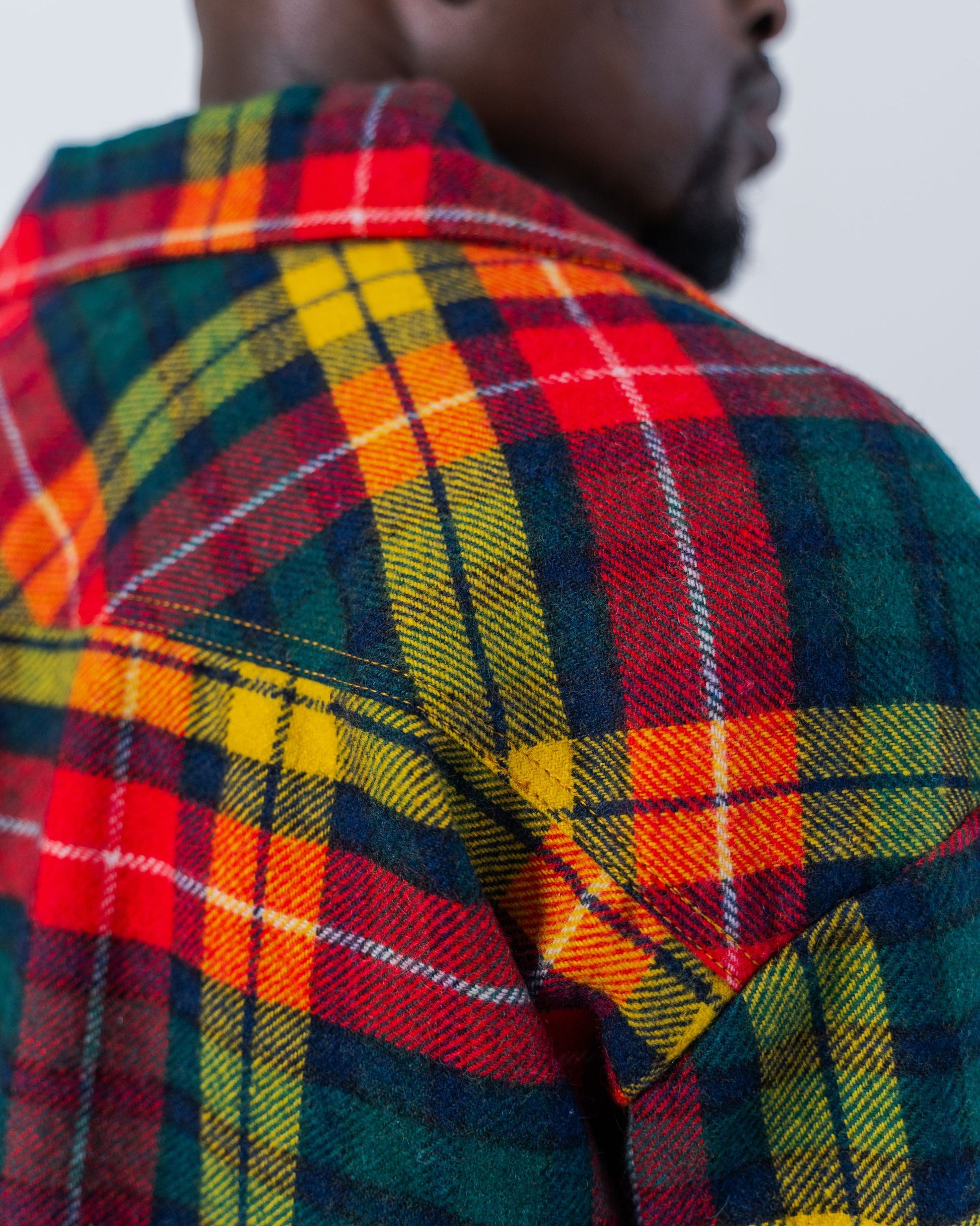 Close-up of a colorful upcycled wool plaid shirt with a blurred background