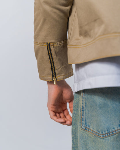 Close-up of a twill weave camel jacket with zipper details on the back