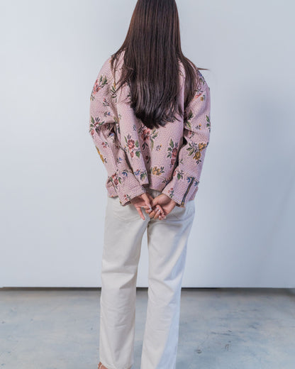 Woman wearing a unisex floral patterned jacket made from sustainable upcycled materials.
