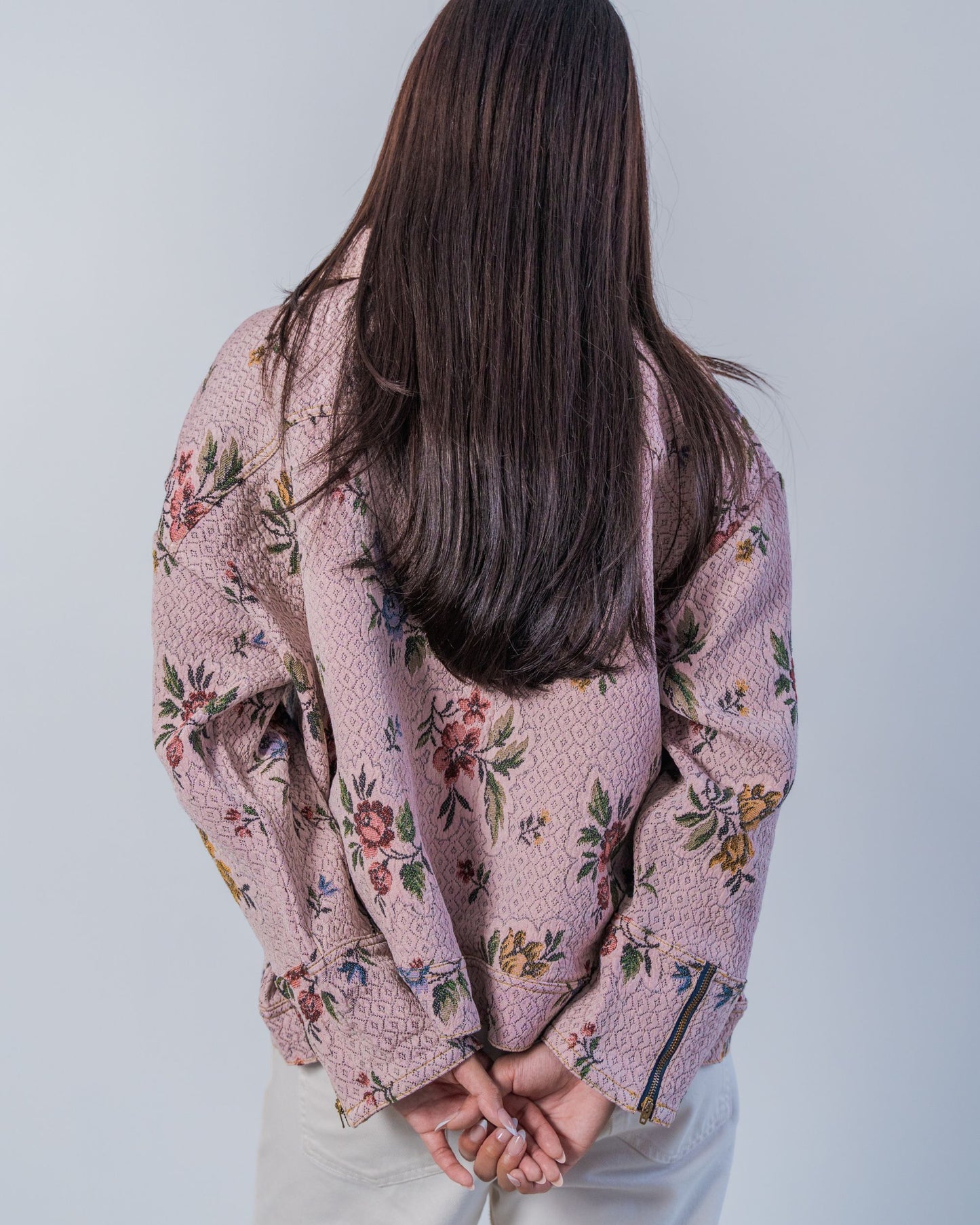 Person wearing a floral-patterned jacket against a plain background