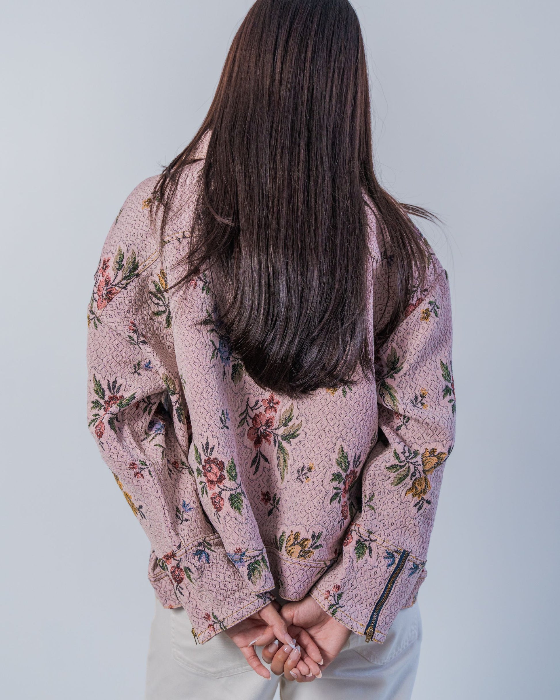 Person wearing a floral-patterned jacket against a plain background