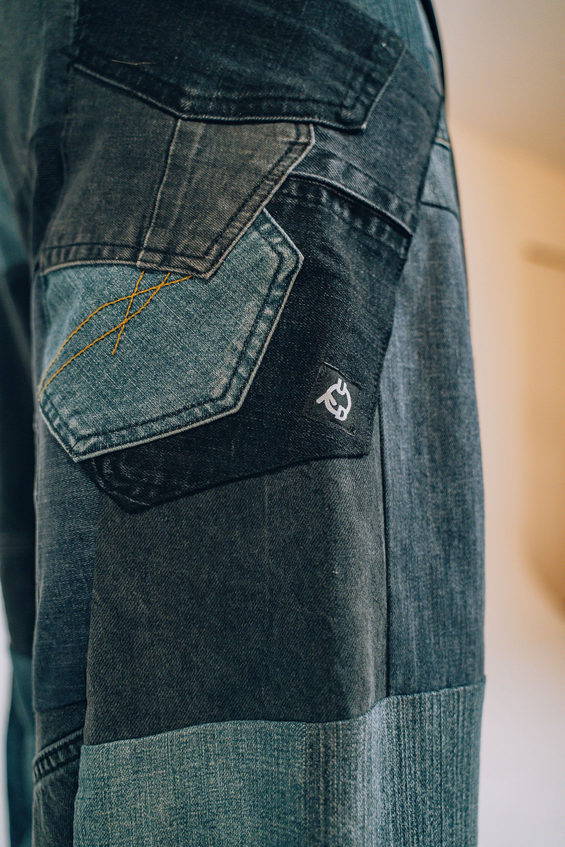 Close-up of a patchwork denim pocket with logo
