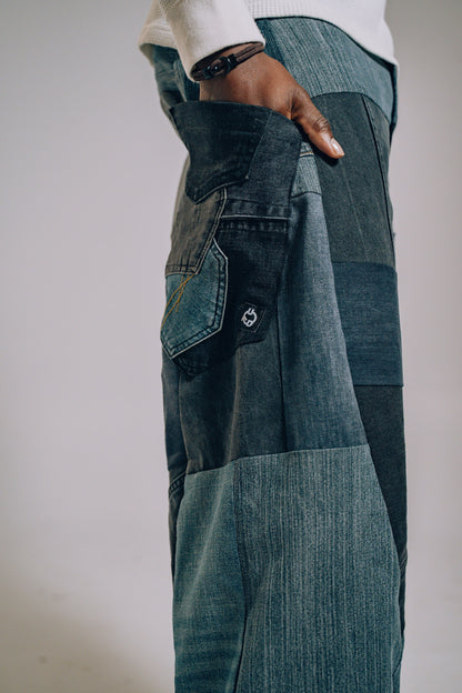 Person wearing patchwork jeans with a neutral background