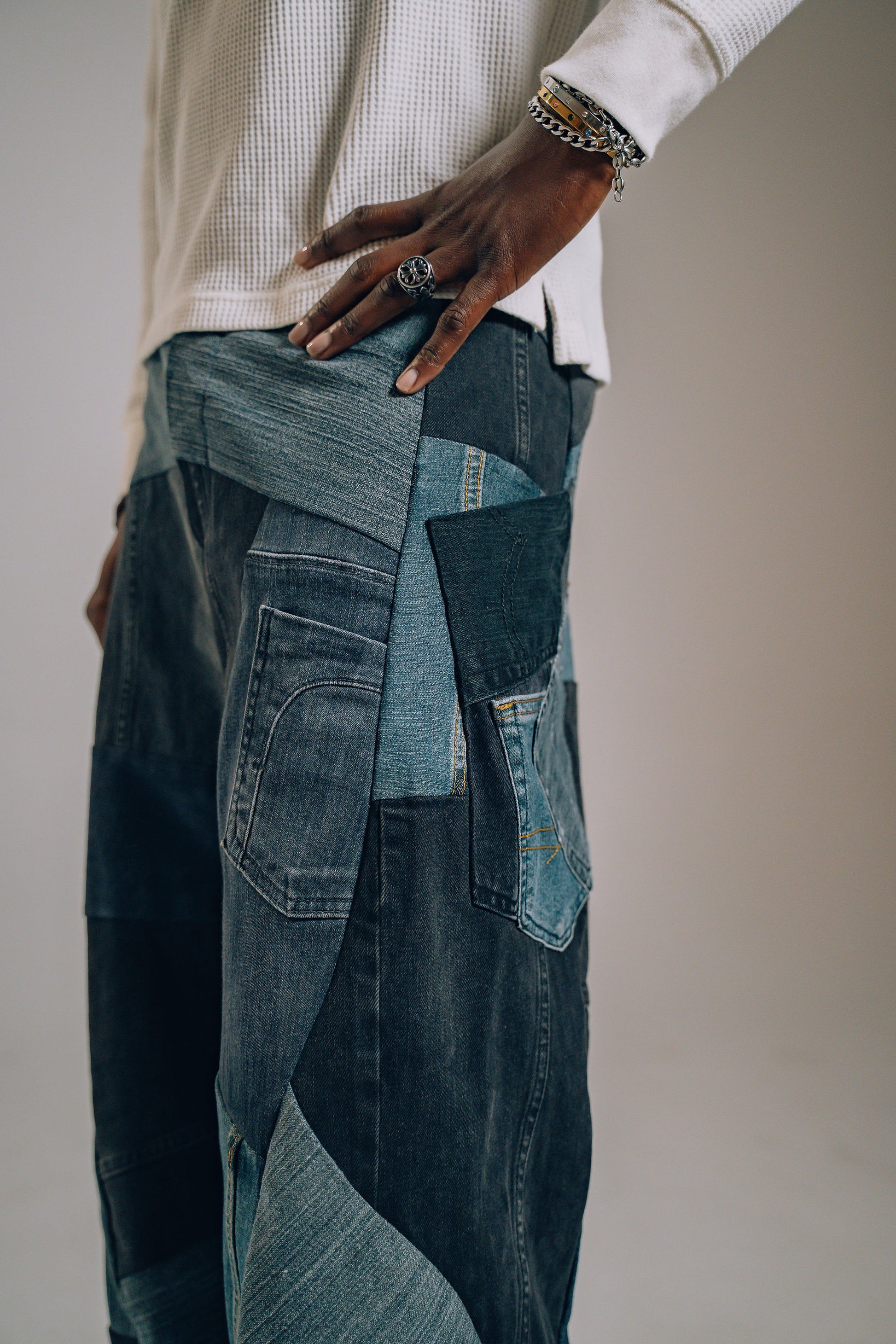 Person wearing a patchwork denim outfit with a neutral background
