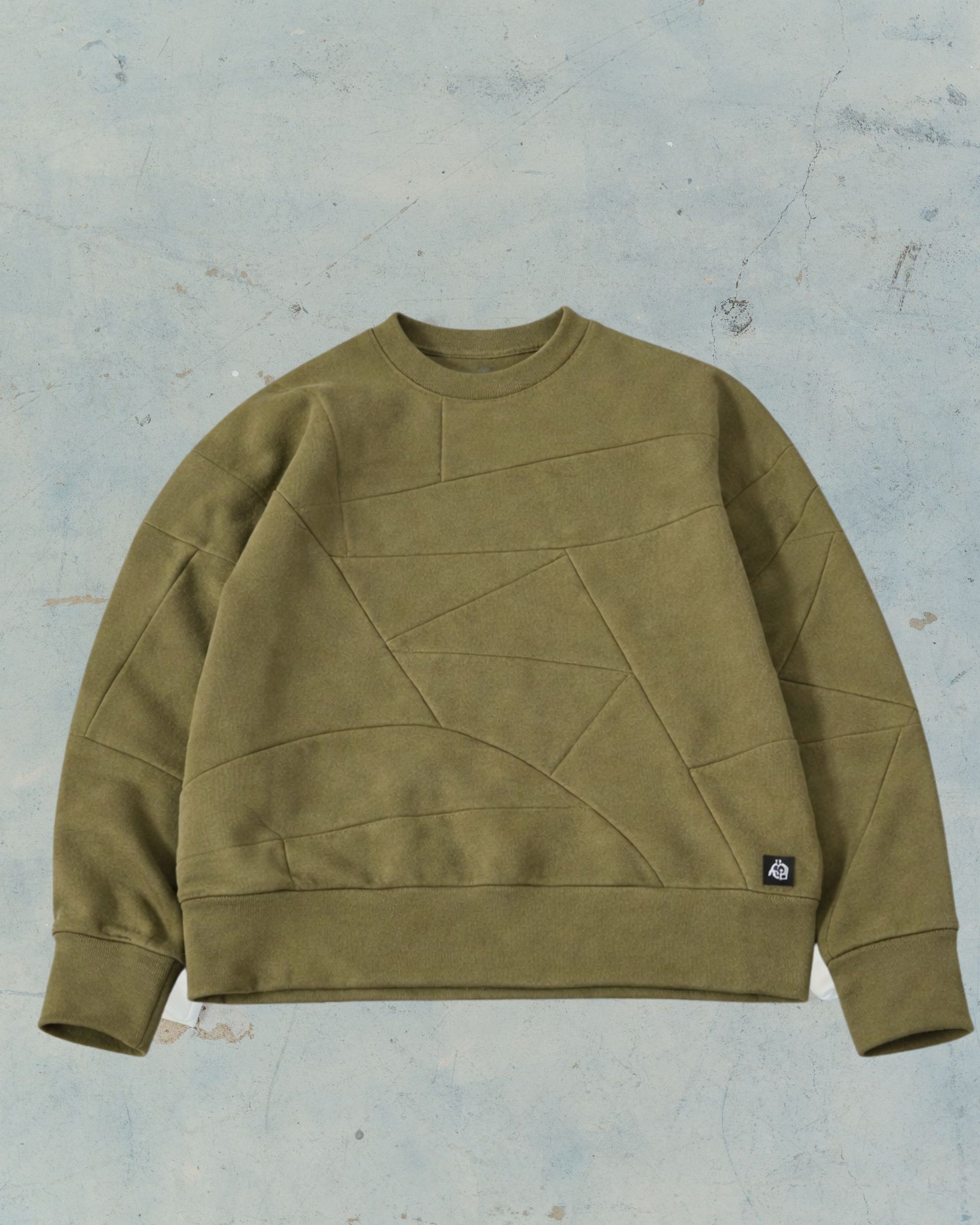 Olive Green patchwork sweatshirt made from organic cotton fabric scraps on a textured gray background